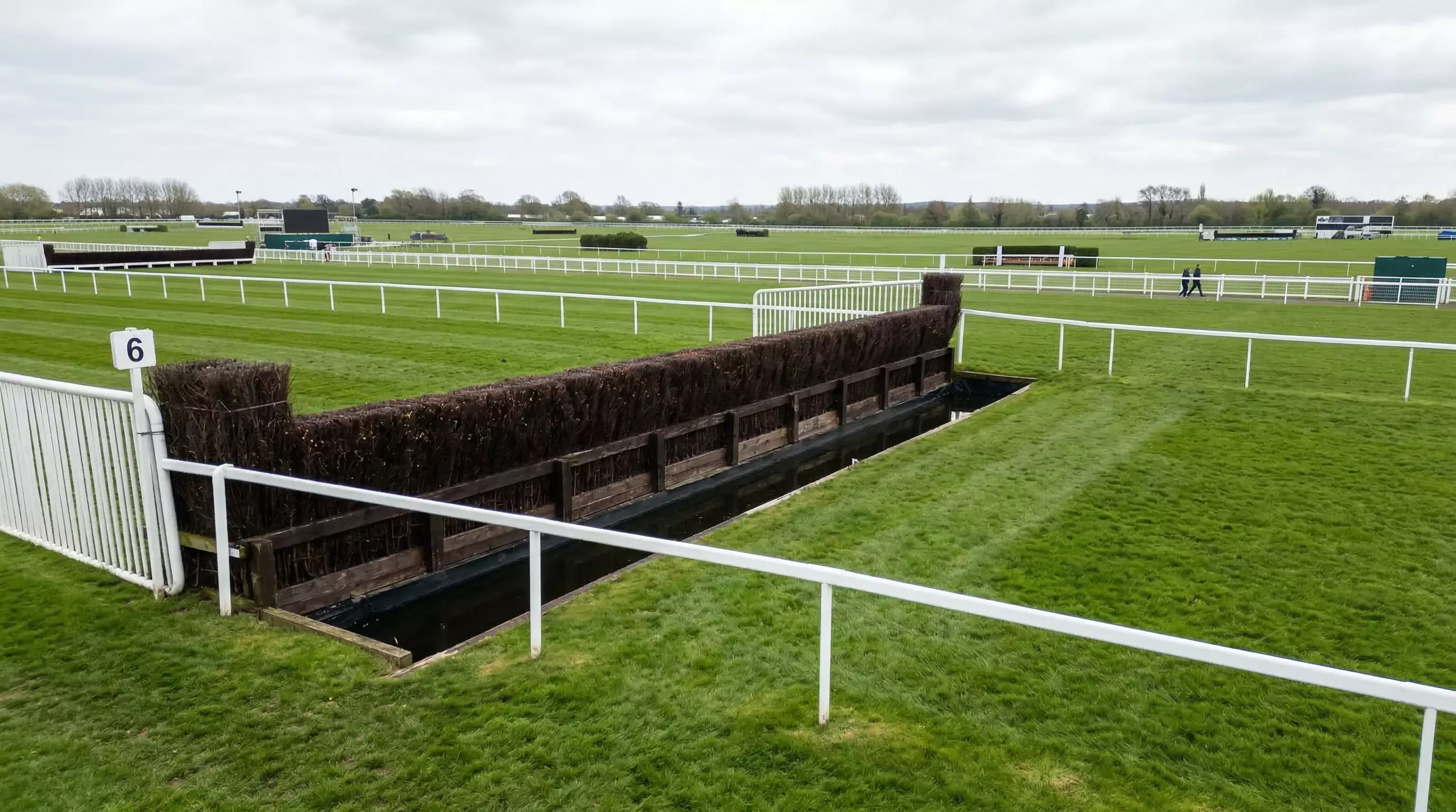 Horses approaching Becher's Brook fence on the Aintree Grand National course with the drop landing visible