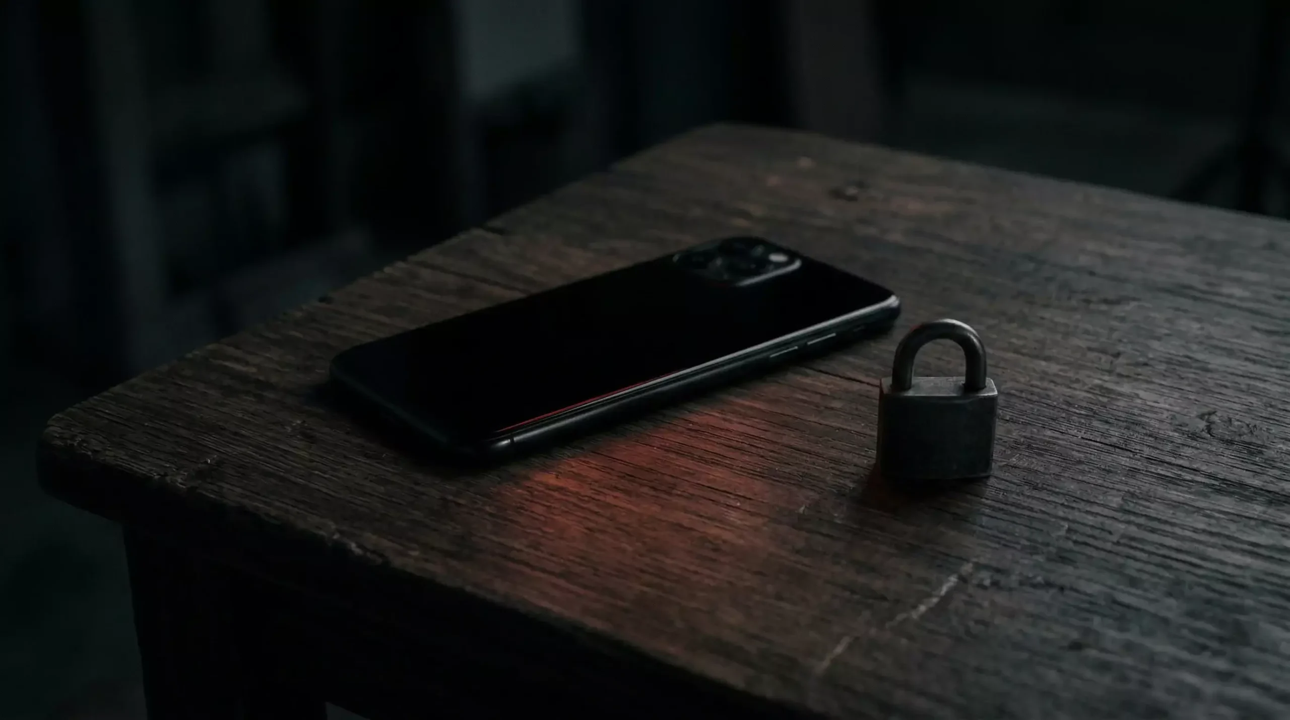 Shadowed smartphone screen with a warning symbol against a dark background