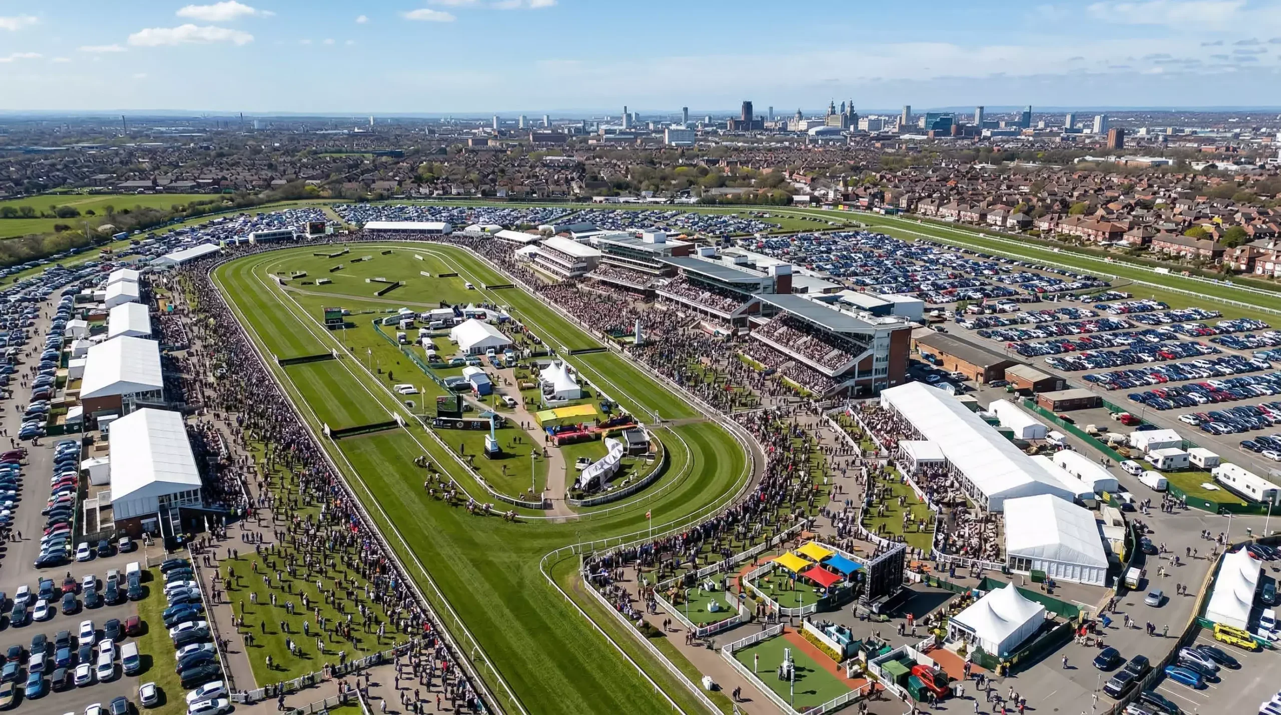 Aerial view of the packed Aintree Festival with Liverpool skyline in the distance