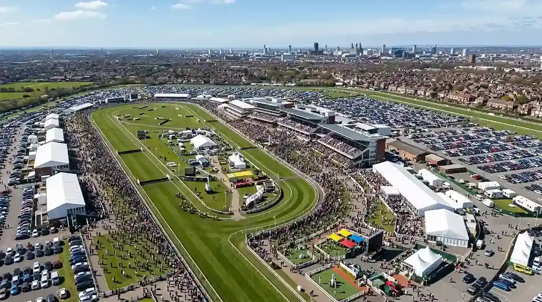 Aerial view of the packed Aintree Festival with Liverpool skyline in the distance